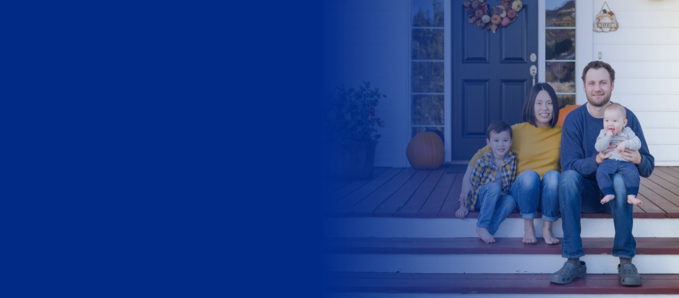 A family of four sitting together on the steps of a front porch.